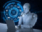 AI robot sitting at desk using a laptop
